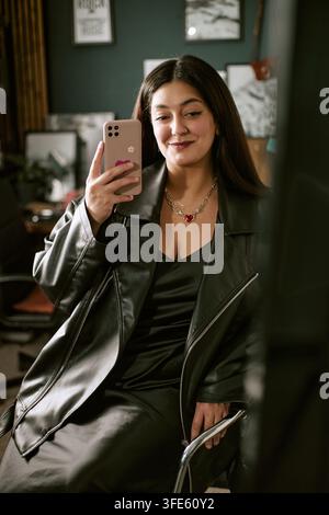 Ritratto di una donna sorridente che scatta un selfie con uno smartphone Foto Stock