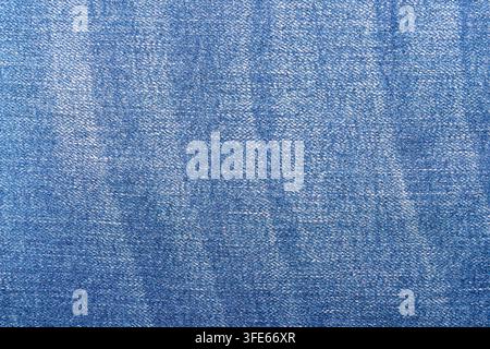 Vista dall'alto di tessuto di jeans blu lavato con striature verticali sbiadite e motivo a saia. Sfondo tessile senza cuciture Foto Stock