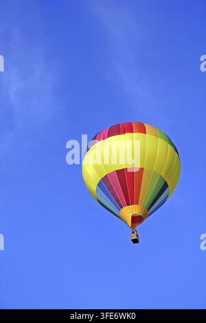 Mongolfiera colorata che galleggia contro un cielo blu, Vienna, Austria Foto Stock