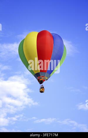 Mongolfiera colorata che galleggia contro un cielo blu, Vienna, Austria Foto Stock