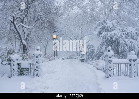 Scena invernale di New York City nel Washington Square Park dopo una tempesta di neve, con alberi, lampioni e sentieri ricoperti di neve a Greenwich Village, Manhattan Foto Stock