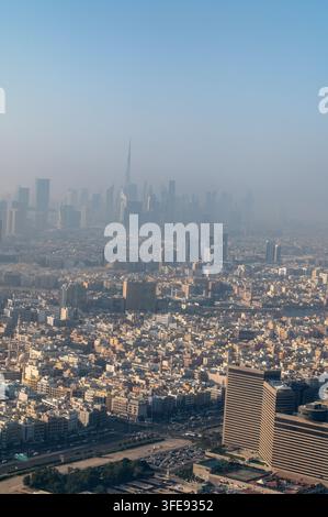 Nella foschia del primo mattino si staglia lo skyline del centro moderno di Dubai con il suo famoso punto di riferimento, il Burj Khalifa, la struttura più alta del mondo, con Foto Stock
