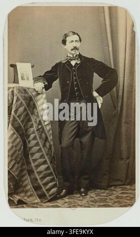 Un uomo in abito formale posa davanti a uno sfondo semplice con un tavolo drappeggiato, in una fotografia di Félix Bazin, fotografo francese del XIX secolo, degli anni '60 dell'Ottocento. Foto Stock