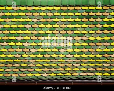 Primo piano di un tradizionale tetto colorato con mattonelle in Alsazia, Francia, caratterizzato da un motivo decorativo di tegole verdi e terracotta Foto Stock