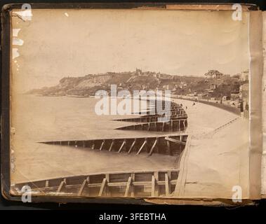 Fotografia della fine del XIX secolo della scena costiera a Sainte-Adresse, vicino Le Havre nella Senna Marittima, Francia, di Neurdein frères, che mostra un lungo molo di legno, una spiaggia sabbiosa e una collina con edifici e alberi. Foto Stock
