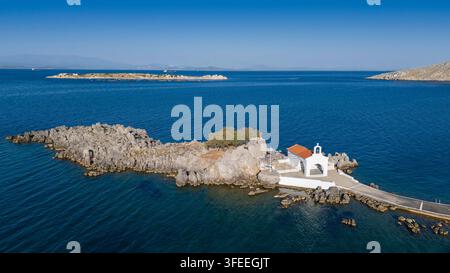 Piccola chiesa di Agios Isidoro nel mare sopra le rocce, isola di Chios, Grecia. Foto Stock