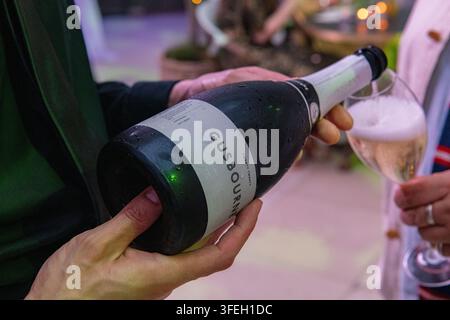Un cameriere versa bicchieri di vino spumante inglese Gusbourne Foto Stock