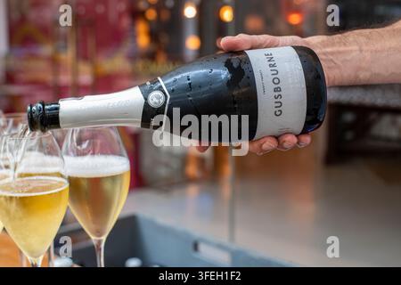 Un cameriere versa bicchieri di vino spumante inglese Gusbourne Foto Stock