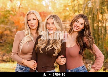 Tre donne felici che sorridono insieme per un ritratto autunnale Foto Stock
