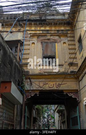 Facciata di edificio dell'era coloniale erosa con una finestra con persiane in legno nella vecchia Dhaka, Divisione di Dhaka, Dhaka, Bangladesh Foto Stock
