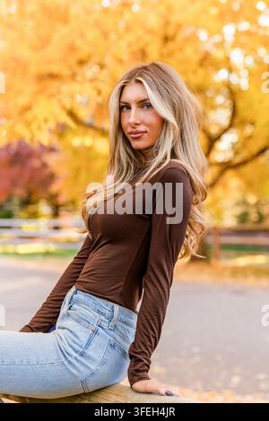Giovane donna elegante in posa in una bella giornata autunnale Foto Stock