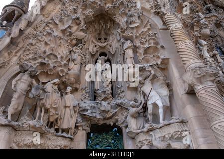 Barcellona, Spagna 01.09.2026 Intagli in pietra coprono la facciata con bassorilievi pallidi di santi e animali. Alte colonne, nicchie intagliate e texture stratificate fra Foto Stock