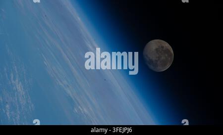 La luna calante appare sopra l'atmosfera blu della Terra in questa immagine scattata dalla Stazione Spaziale Internazionale Foto Stock