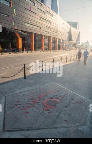 Una Rosa di Sarajevo segna la cicatrice della guerra nel marciapiede, contrastando il doloroso ricordo della guerra di Sarajevo con la città moderna e la sua vita quotidiana, S Foto Stock