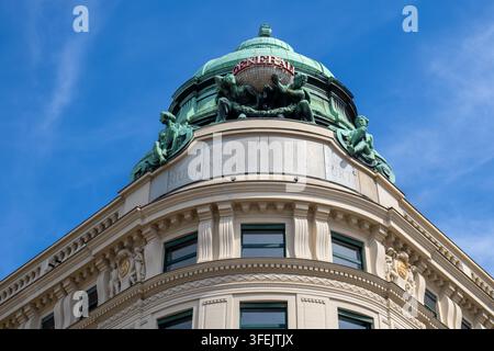 Vista della cupola storica dell'edificio Generali, che mostra intricate sculture in bronzo e il testo inciso Riunione Adriatica di Sicurta a Vienna, Austria Foto Stock