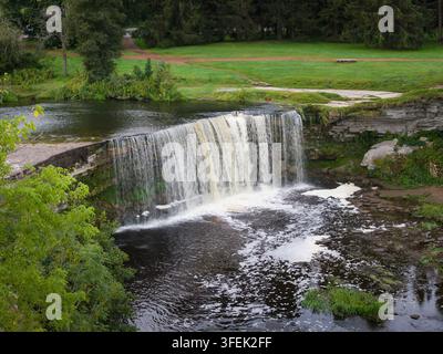 Fotografia aerea con drone che cattura la cascata di Jagala, la più ampia cascata naturale dell'Estonia, che scorre su una scogliera di calcare in una valle fluviale boscosa Foto Stock