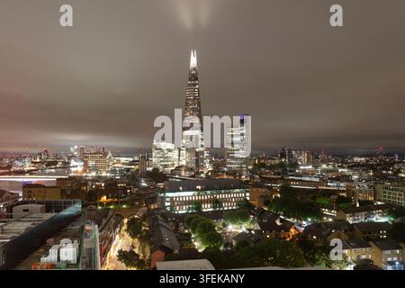 Il grattacielo illuminato dello Shard si erge su Southwark nel centro di Londra, mostrando lo skyline notturno vivace vicino al Tamigi. Foto Stock