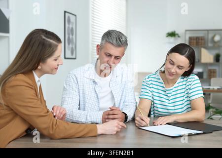Notaio che lavora con i clienti al tavolo in ufficio Foto Stock