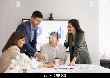 Staff divers e felice dell'ufficio che gode di un'interazione amichevole alla scrivania della sala riunioni Foto Stock