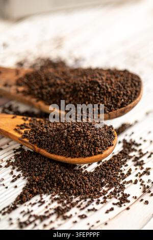 Tè nero granulato in cucchiai di legno sul tavolo Foto Stock