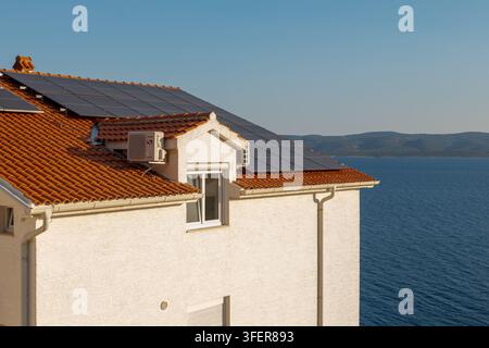 MIMICE, CROAZIA, 4 settembre 2026: Una casa moderna con pannelli solari sul tetto si trova accanto a un mare blu e calmo. Foto Stock