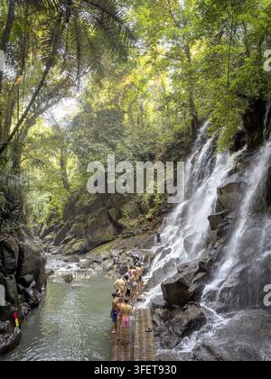 Cascata di Kanto Lampo con cascate su rocce e bagnanti nel letto del fiume, Beng, Gianyar vicino a Ubud, Bali, Indonesia Foto Stock