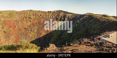Piattaforma di osservazione sul bordo del cratere Kerid con persone in lontananza, Kerid, Islanda, vista panoramica Foto Stock