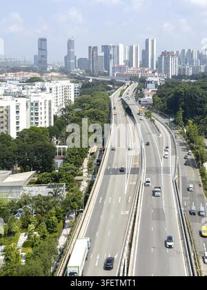 Vista dalla Singapore Cable Car sull'autostrada a quattro corsie curva di West Coast Highway con traffico automobilistico e skyline moderna sullo sfondo, Singapore Foto Stock