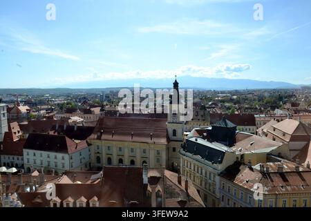 Vista panoramica della Torre del Consiglio di Sibiu e della Piazza Grande con le montagne Făgăraş sullo sfondo, Sibiu, Transilvania, Romania. Foto Stock