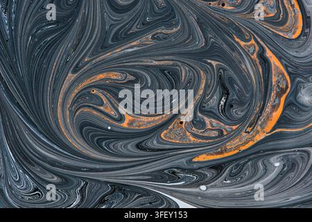 Modello astratto di vortici di vernice liquida che mostra marmo grigio scuro con linee di accento arancioni vivaci Foto Stock