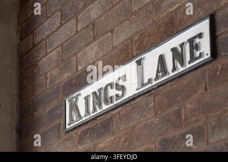 Un cartello stradale "Kings Lane" montato su un muro di mattoni a Cambridge, Inghilterra, che segna la strada storica vicino all'Università di Cambridge. Foto Stock