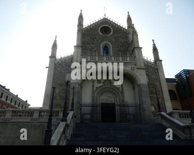 Facciata di San Jeronimo el Real a Madrid, Spagna, che mostra l'ingresso gotico isabellino e la scalinata in pietra illuminati da un sole splendente di mezzogiorno. Foto Stock