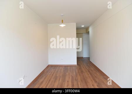 Interno di stanza vuota moderna con pavimento in parquet di legno, pareti bianche e grande finestra, architettura di appartamento contemporanea con luce naturale e spaziosità Foto Stock