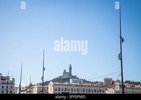 Basilica Notre-Dame de la Garde, nota localmente anche come Bonne Mere, si erge sopra lo skyline della città dalla sua posizione sulla cima della collina, vista sotto un chiaro cielo blu Me Foto Stock