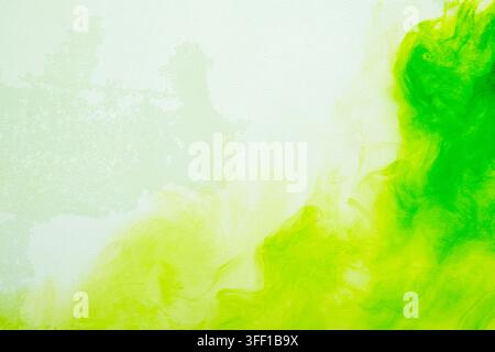 Uno sfondo astratto vibrante con inchiostro o pittura acquerello verde brillante e giallo limone che si diffonde e si muove dolcemente su una tela leggera e texture Foto Stock