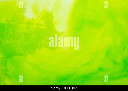 Uno sfondo astratto vibrante con inchiostro o pittura acquerello verde brillante e giallo limone che si diffonde e si muove dolcemente su una tela leggera e texture Foto Stock