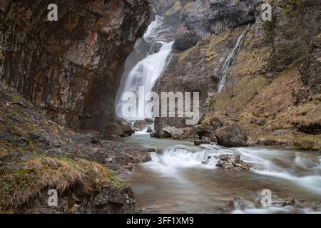 Cascata della valle di Ordesa che scende lungo scogliere rocciose formando un ruscello sereno con acqua a lunga esposizione Foto Stock
