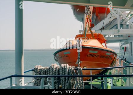 Canotto di salvataggio arancione fissato sul sistema di daviteria di una nave passeggeri su uno sfondo acquatico - 4 settembre 2026. Foto di alta qualità Foto Stock