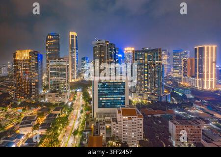 Splendida vista aerea dello skyline di Giakarta di notte, che mostra grattacieli moderni illuminati e strade urbane vivaci nel distretto degli affari. J Foto Stock