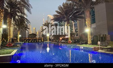 Ambientazione del primo pomeriggio sul Burj Khalifa alto, appartamenti e uffici moderni rialzati attorno al molo della piscina all'aperto illuminato al JW M Foto Stock