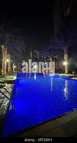 Ambientazione del primo pomeriggio sul Burj Khalifa alto, appartamenti e uffici moderni rialzati attorno al molo della piscina all'aperto illuminato al JW M Foto Stock