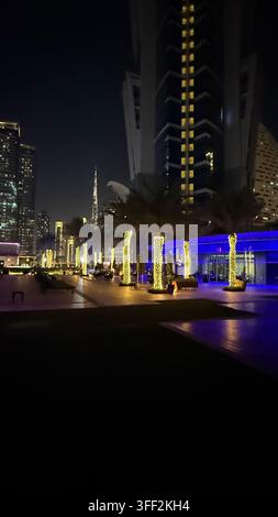Ambientazione del primo pomeriggio sul Burj Khalifa alto, appartamenti e uffici moderni rialzati attorno al molo della piscina all'aperto illuminato al JW M Foto Stock