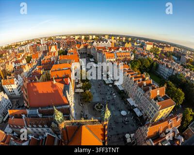 Vista aerea che cattura la storica chiesa di Santa Maria a Danzica, circondata da tetti colorati alla luce del sole. La scena evidenzia Foto Stock