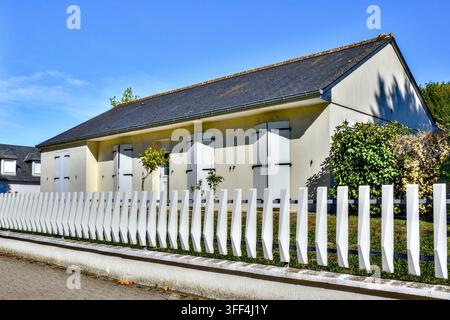 Casa bungalow moderna con una lunga recinzione di plastica bianca che delimita il giardino anteriore - Loches, Indre-et-Loire (37), Francia. Foto Stock