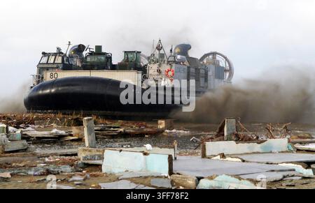 050113-M-5538E-022 Un Landing Craft Air Cushion della U.S. Navy, comunemente chiamato LCAC, solleva sabbia atterrando sulla spiaggia di Meulaboh, Indonesia, il 13 gennaio 2005. L'LCAC, schierato a bordo della USS Bonhomme Richard (LHD 6), sta trasportando forniture umanitarie dalla nave a Meulaboh. Il Bonhomme Richard Expeditionary Strike Group sta attualmente operando nell'Oceano Indiano al largo delle coste dell'Indonesia e della Thailandia, a supporto dell'Operazione Unified Assistance. Foto DoD di Lance Cpl. Scott L. Eberle, U.S. Marine Corps. (Rilasciato) Foto Stock