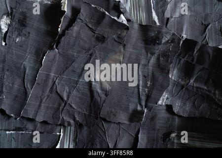 Texture astratta di collage nero in stile punk realizzata con pezzi di carta strappati e accartocciati con texture di stampa a getto d'inchiostro a righe Foto Stock
