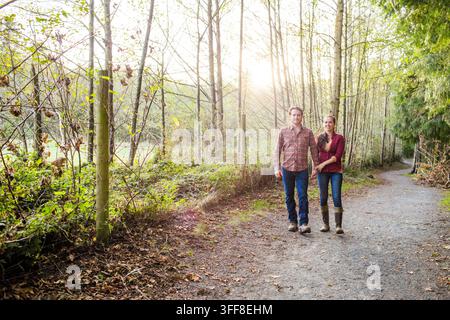Coppia felice che fa una passeggiata romantica nel bosco Foto Stock