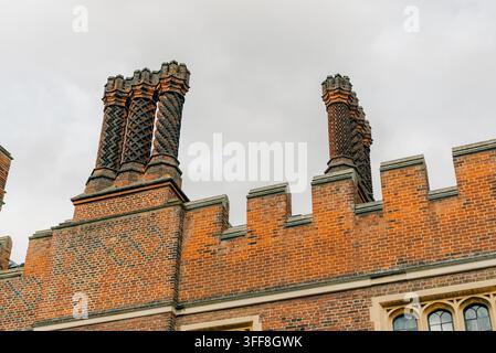Famosi camini decorativi in mattoni Tudor sul tetto di Hampton Court Palace in Inghilterra, caratterizzati da intricati motivi attorcigliati, geometrici e a spirale Foto Stock