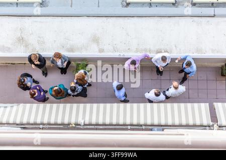 Una vista a volo d'uccello di un gruppo di colleghi d'ufficio che chiacchierano durante una pausa su una terrazza all'aperto Foto Stock
