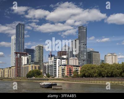 Panorama della skyline di Londra sul Tamigi con grattacieli moderni ed edifici sul lungofiume nel distretto finanziario. Una piccola chiatta in primo piano Foto Stock